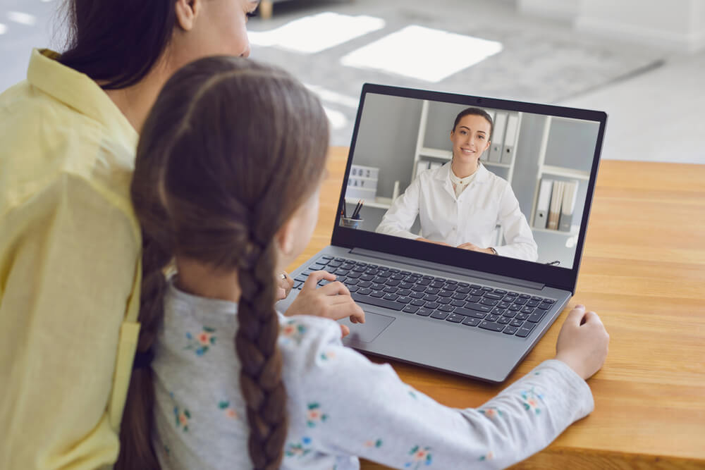 A woman and child join a telehealth call, highlighting digital marketing agency services.