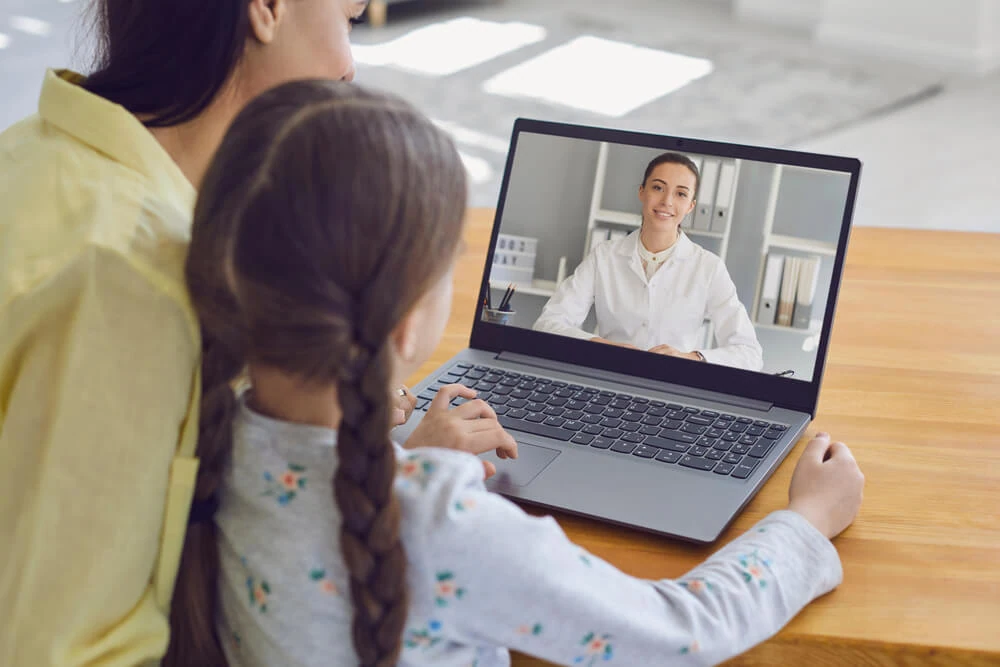 A woman and child join a telehealth call, highlighting digital marketing agency services.