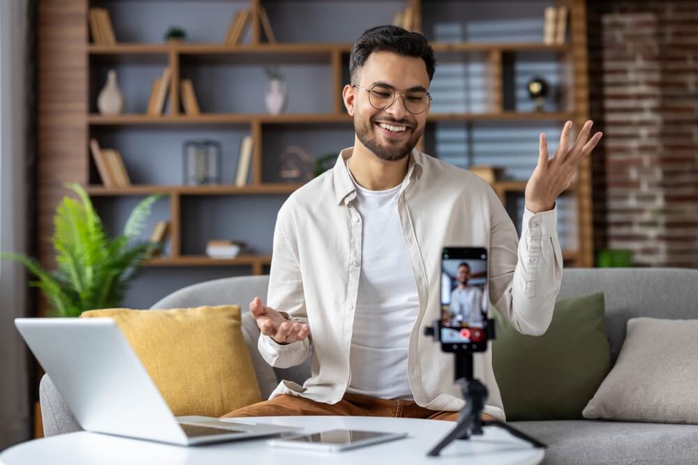 A man livestreams from his living room, creating content for a digital marketing agency.