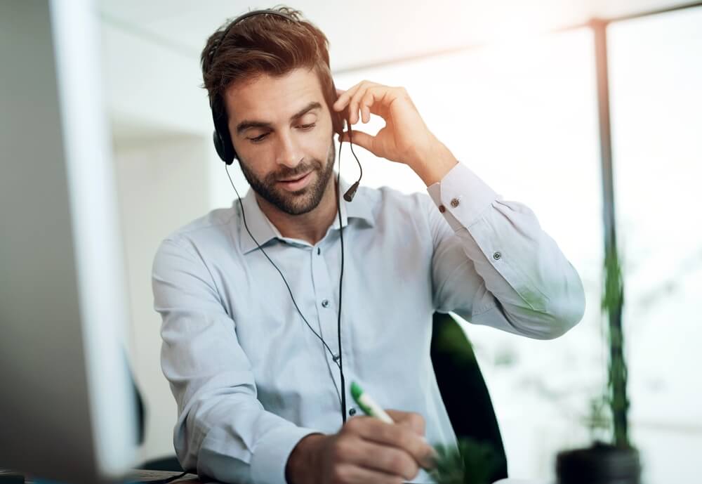 A digital marketing agency expert reviews SEO services at a desk with a headset.