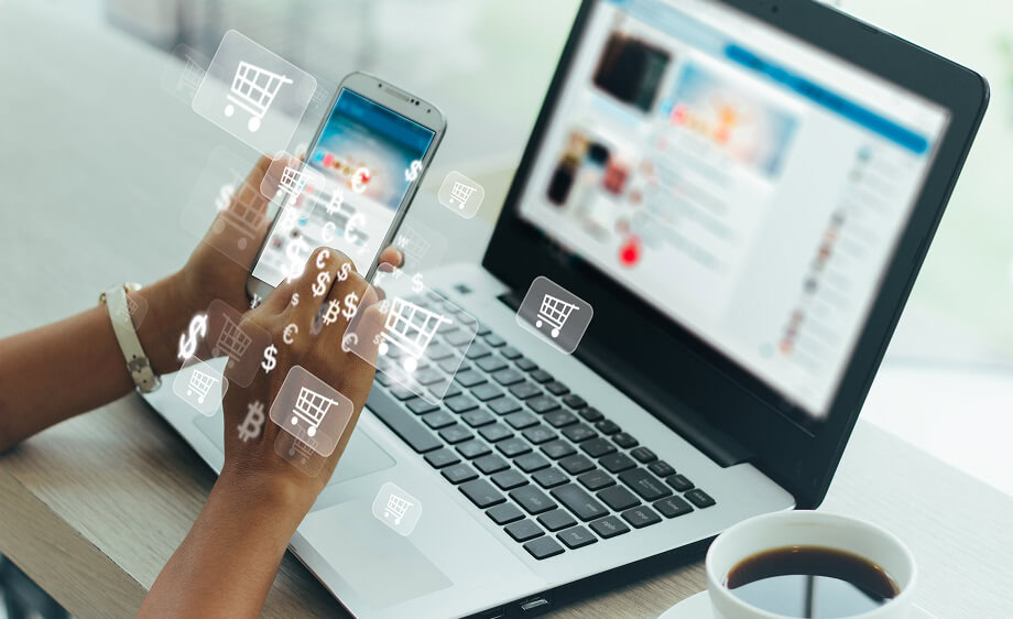 A person using a smartphone and laptop with digital marketing and SEO icons displayed.