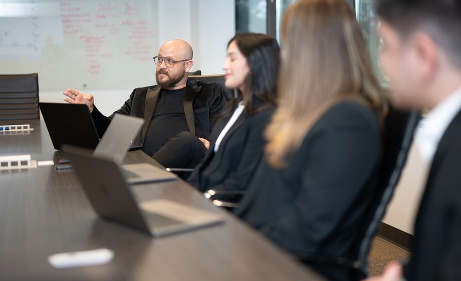 Four digital marketing professionals discuss SEO and social media strategy at a meeting.