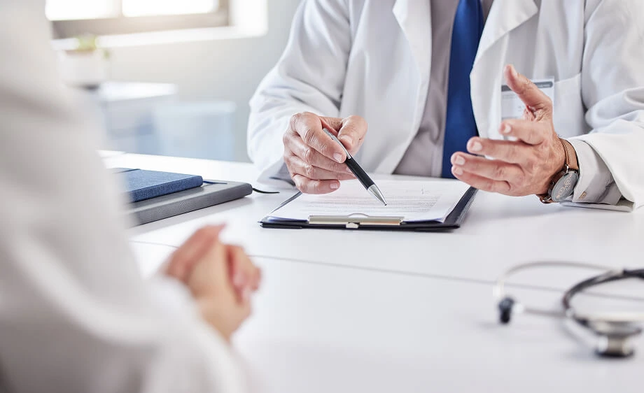 A doctor and patient discuss home services as digital marketing brochures are displayed.