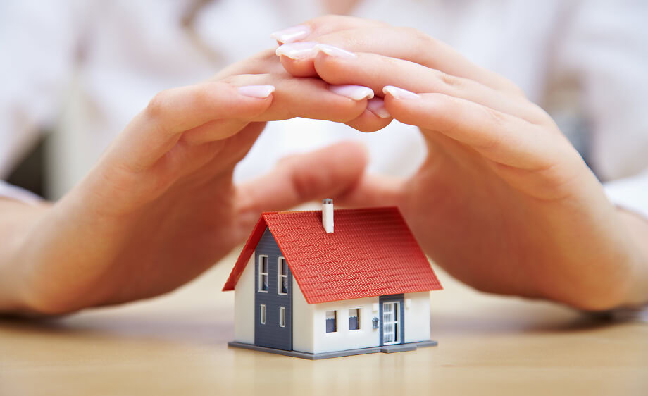 Hands cupped over a model house, symbolizing SEO and home services marketing.