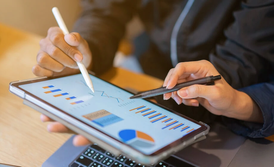 Two marketers analyze SEO reports and content strategy on a tablet for a digital agency.