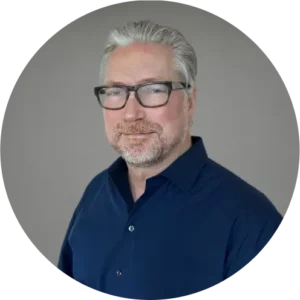 Henrik Johansson, a digital marketing agency expert, in glasses and navy shirt, poses professionally.