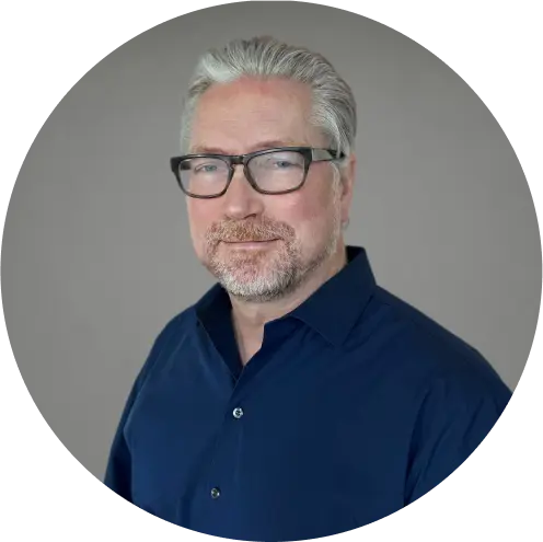 Henrik Johansson, a digital marketing agency expert, in glasses and navy shirt, poses professionally.
