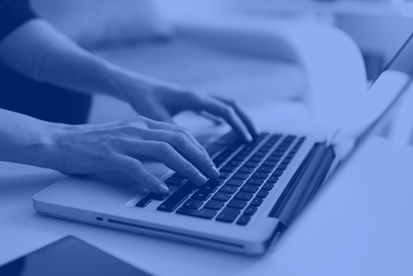 Hands typing on laptop for SEO services at a digital marketing agency desk.