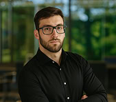 David Szakacs, digital marketing expert, stands confidently in a modern office.