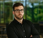 David Szakacs, digital marketing expert, stands confidently in a modern office.