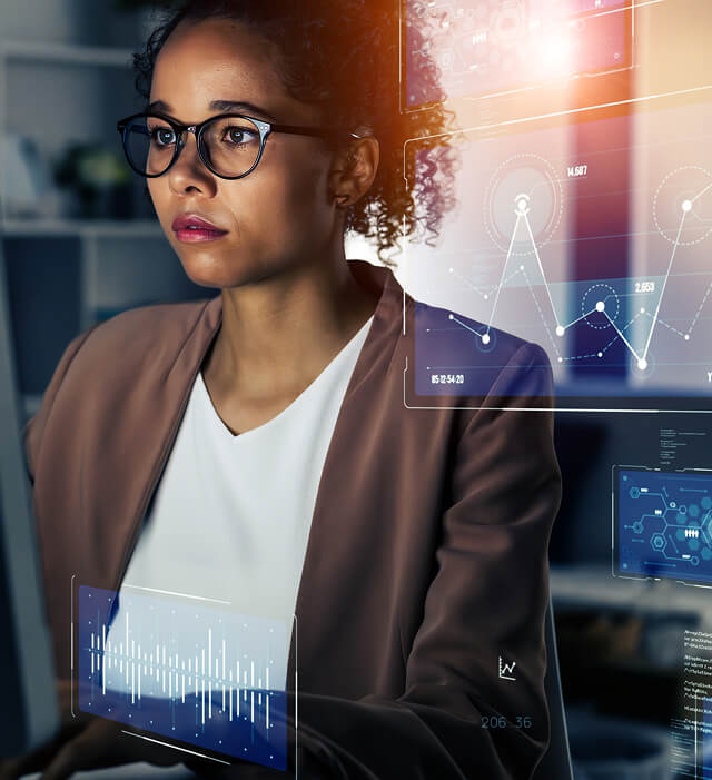 A woman analyzes SEO, content marketing, and paid media data on digital screens in an agency office.