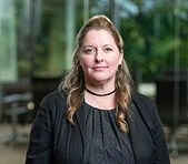 A digital marketing agency professional stands indoors with office background.