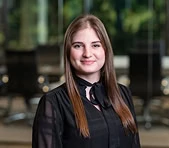 A woman in a black blouse stands in a digital marketing agency office setting.