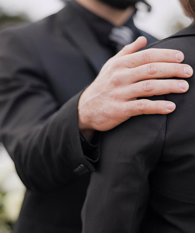 A person in a black suit comforts another, illustrating digital marketing agency support.
