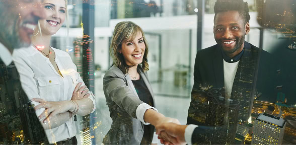 Four professionals in a digital marketing agency office, two shaking hands, city view.