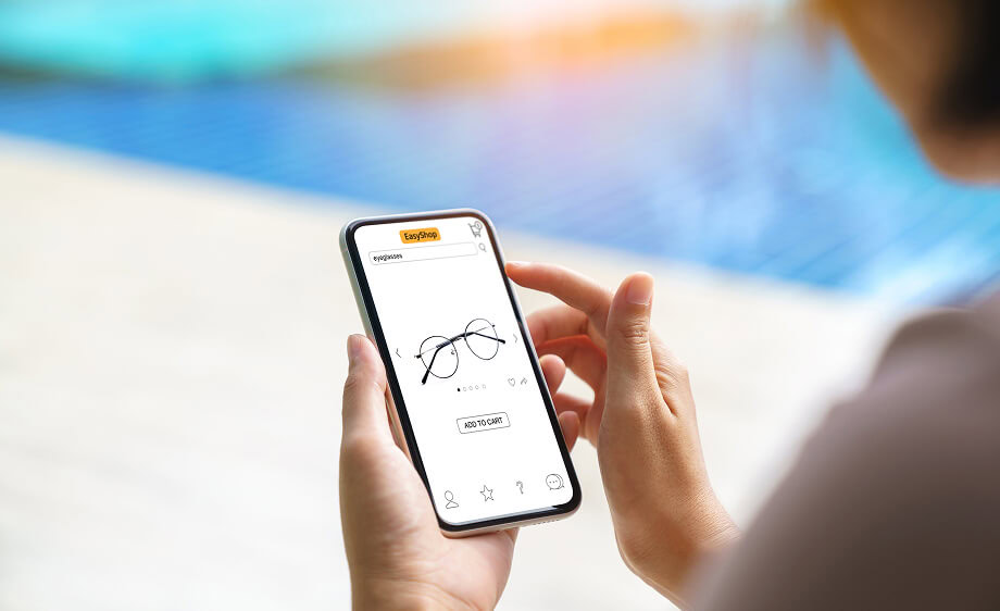 A hand holds a smartphone with an ecommerce site by a digital marketing agency.