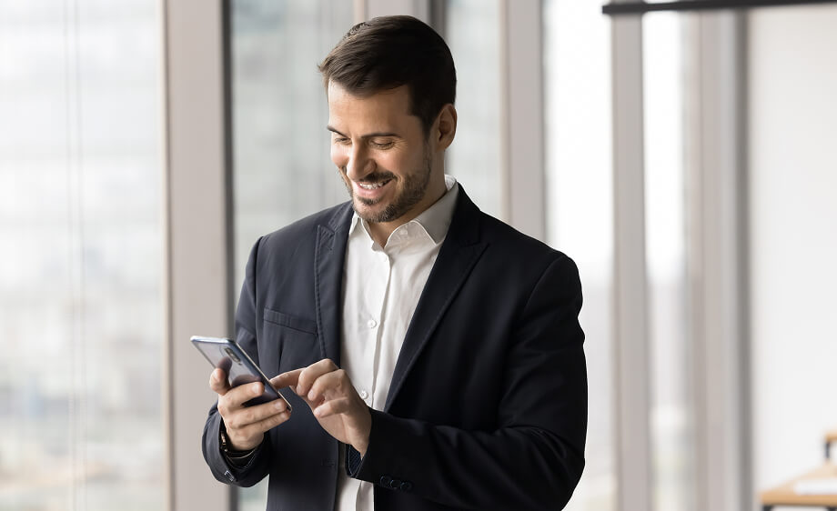 A man in a suit uses his smartphone for SEO and call tracking at a digital marketing agency.