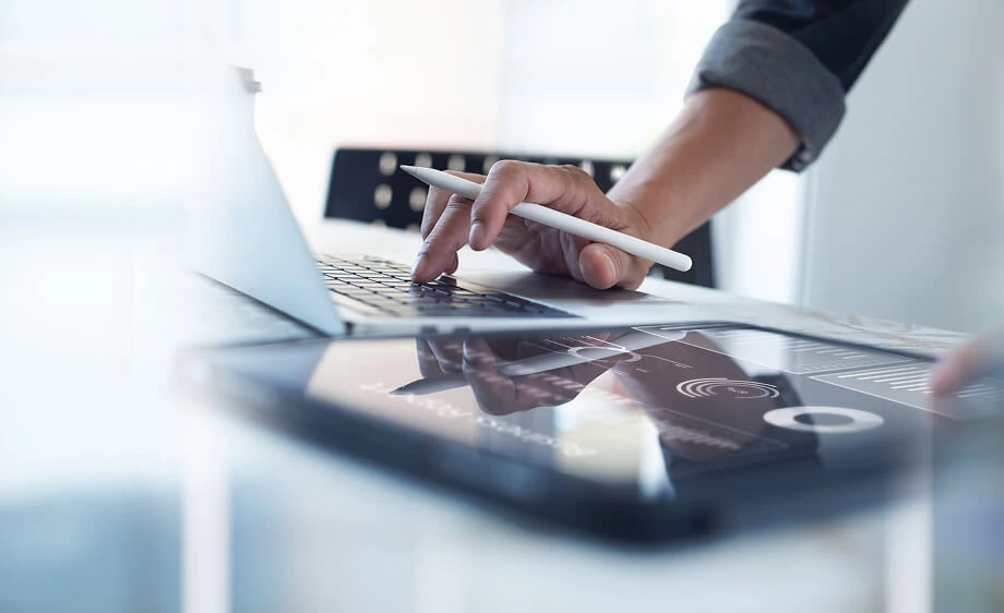 A digital marketing agency expert analyzes SEO and paid media data on a tablet.