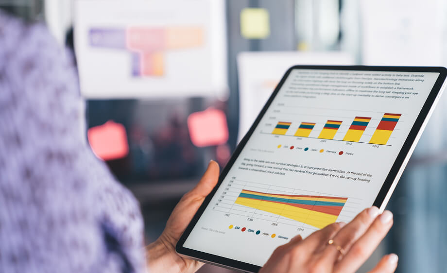 Person holding a tablet with analytics charts for a digital marketing agency campaign.