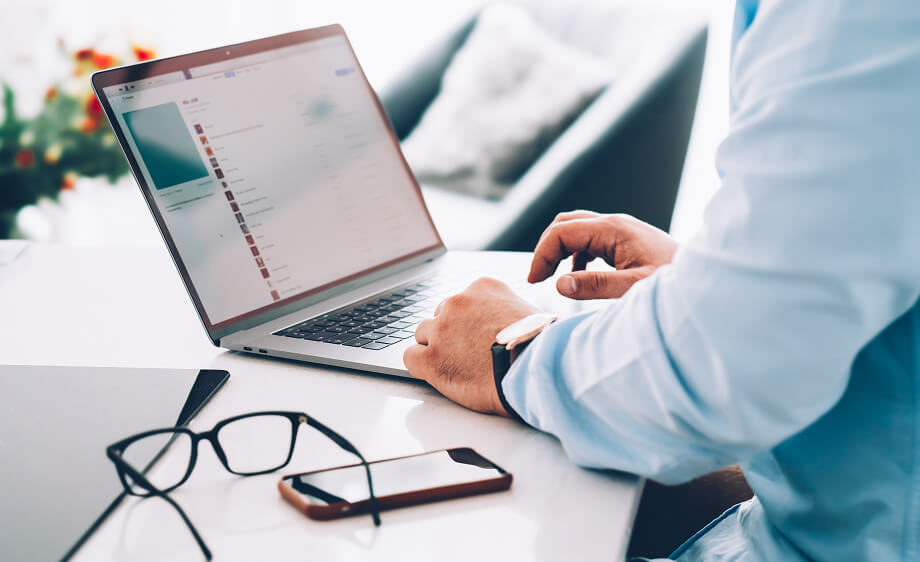 A person works on a laptop researching SEO and email marketing for a digital agency.