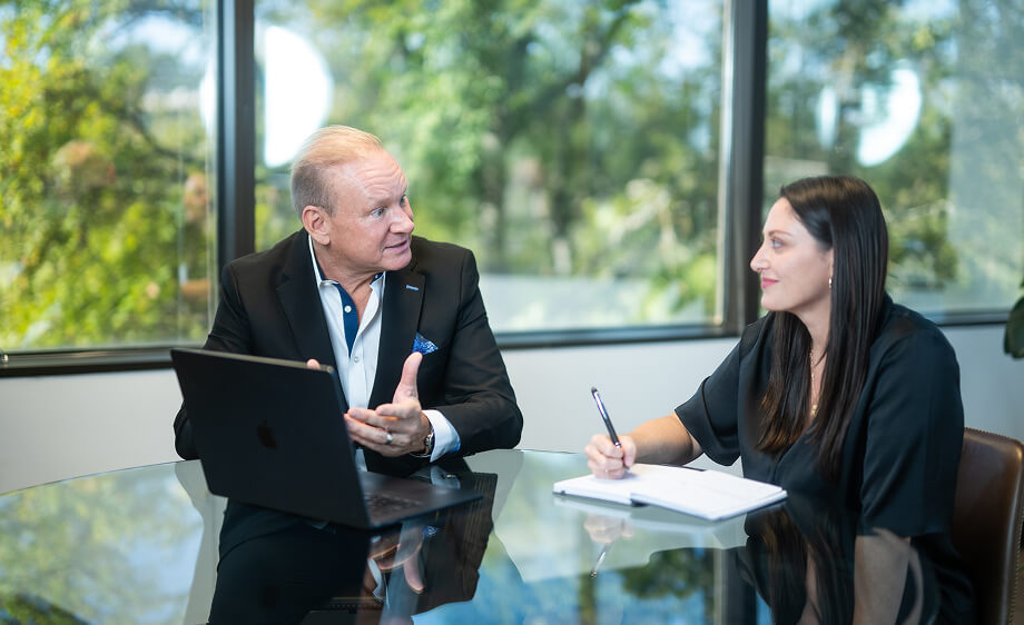 Two marketers discuss Google Ads strategy at a digital marketing agency office.