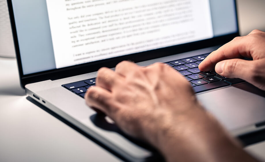 Hands typing on a laptop with SEO services and content marketing strategies onscreen.