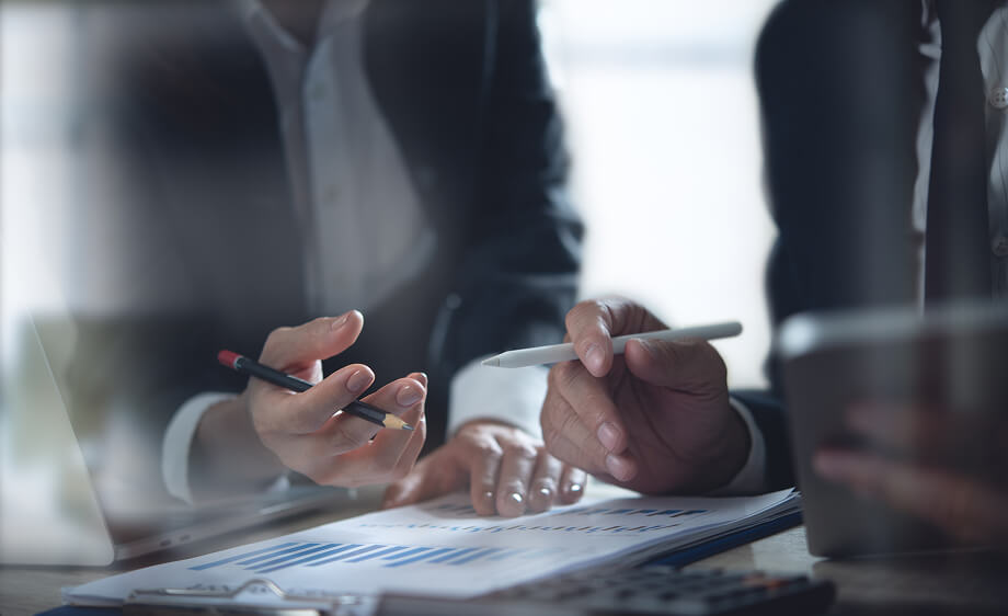Two marketers review SEO reports and social media data at a digital agency table.