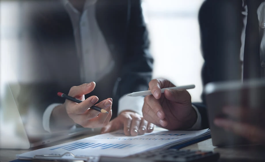 Two marketers review SEO reports and social media data at a digital agency table.