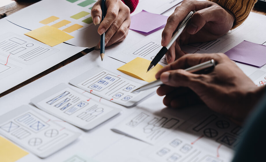 Digital marketing agency team reviews web development and SEO strategy sketches.