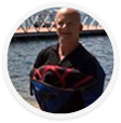 A digital marketing agency expert stands by water, holding branded materials.