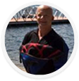 A digital marketing agency expert stands by water, holding branded materials.
