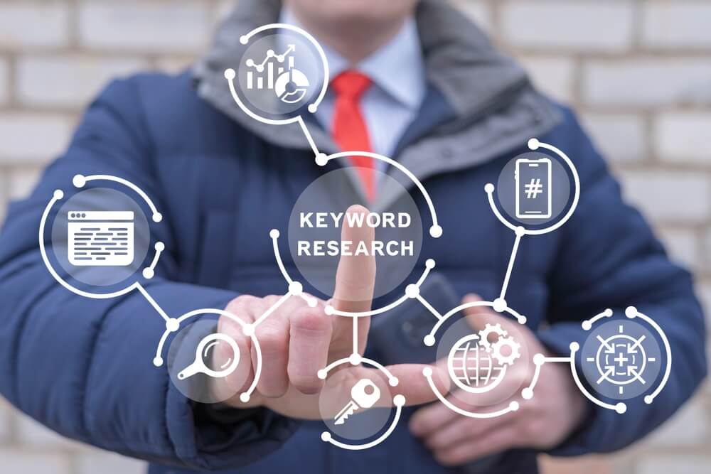 A marketing professional in a suit points at a digital interface with "Keyword Research," SEO services, and digital marketing agency icons.