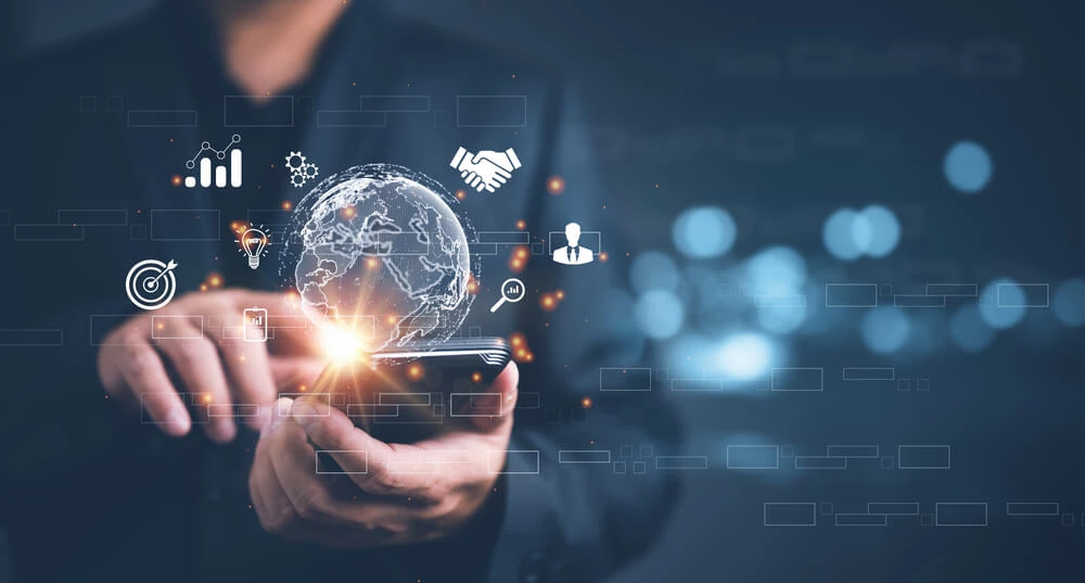 Business professional holding smartphone with digital globe and icons, representing SEO services, social media marketing, and web development.