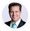 Dr. Jonathan Calure, in a suit, smiles at the camera as a digital marketing agency expert.