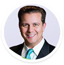 Dr. Jonathan Calure, in a suit, smiles at the camera as a digital marketing agency expert.