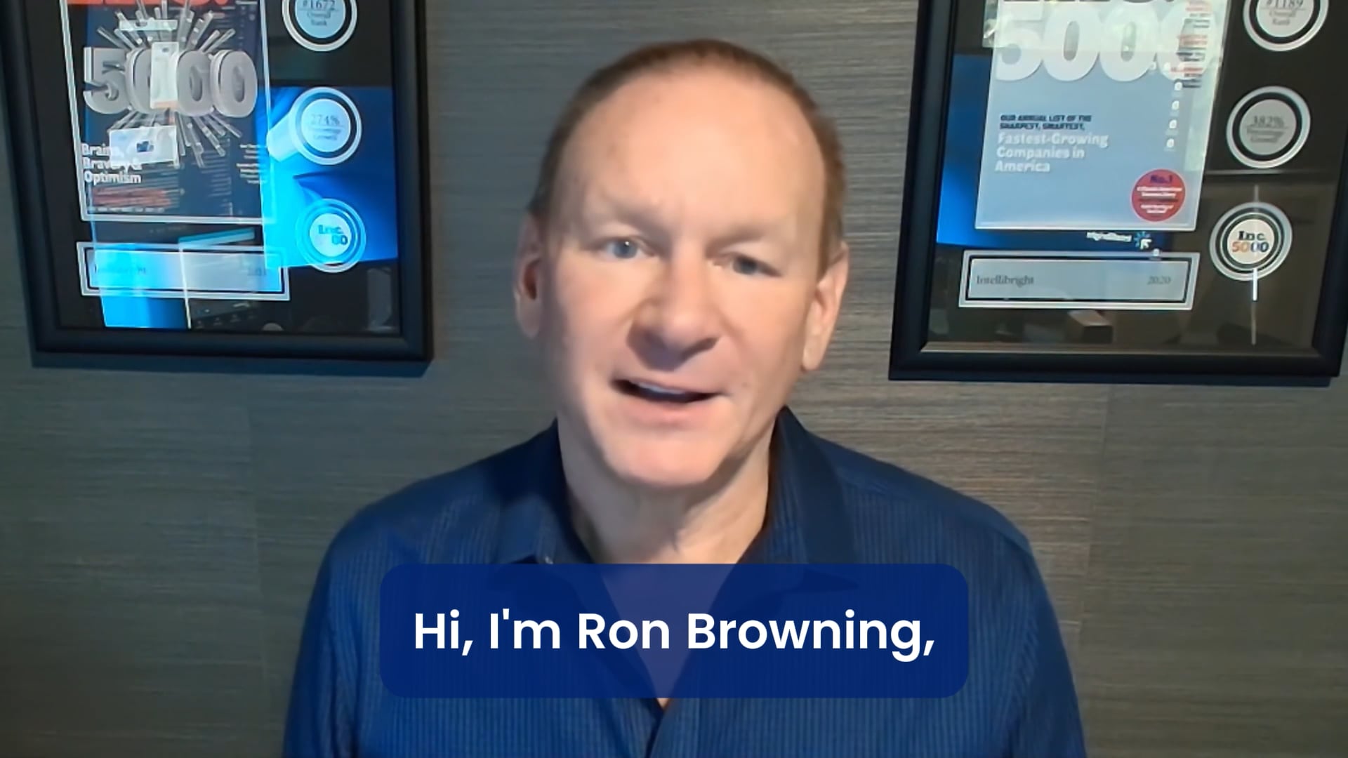 A man in a blue shirt stands before framed awards, introduced as Ron Browning from SalesLeap, a digital marketing agency.
