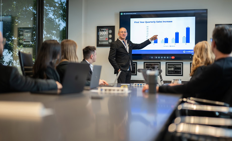 A digital marketing agency executive presents a bar chart on Black Friday SEO and sales data.
