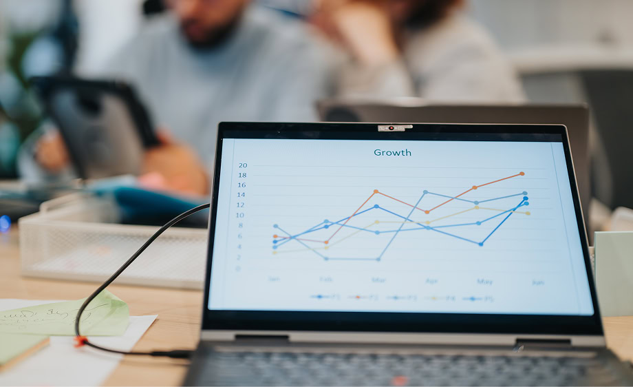 A laptop shows a "Growth" campaign graph, with digital marketing and SEO experts blurred behind.