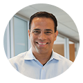 David Cardona, smiling digital marketing agency professional, stands by office windows.