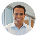 David Cardona, smiling digital marketing agency professional, stands by office windows.