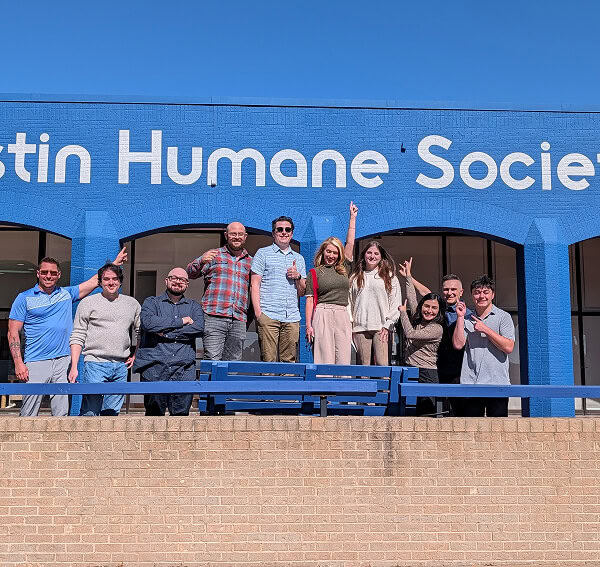 Ten digital marketing agency team members pose at Austin Humane Society building.