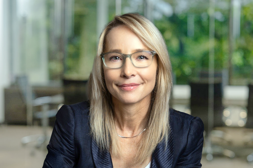 Chelsey Langan, digital marketing strategist, in a modern office with glass walls and greenery.