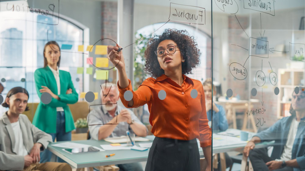 A woman leads a digital marketing agency meeting on SEO services while colleagues observe.