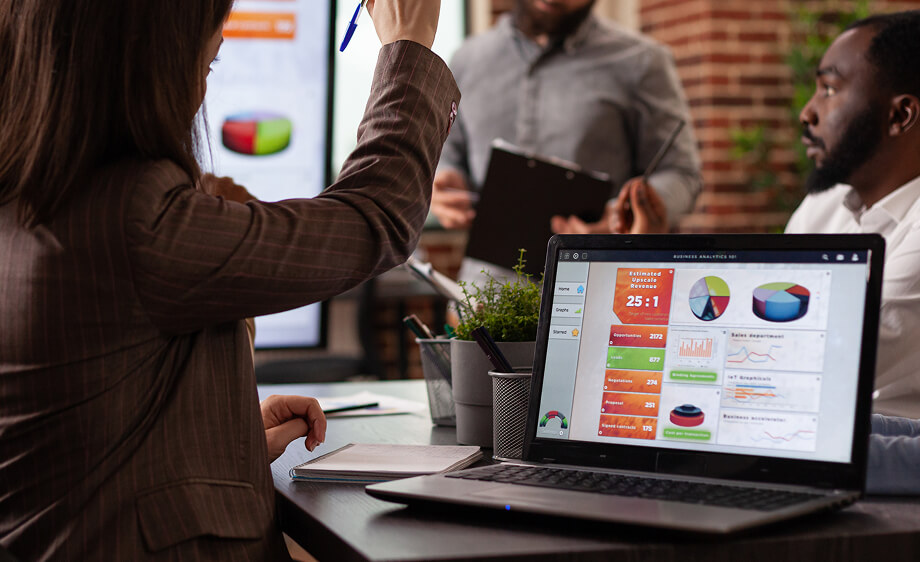 Team at digital marketing agency reviews SEO dashboards and social media analytics on a laptop.