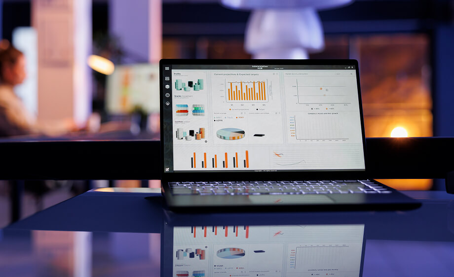 A laptop with analytics graphs sits on a desk, highlighting SEO, PPC, and content marketing insights.