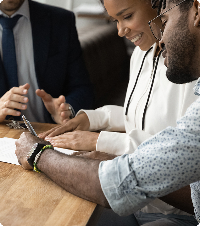 Couple signing mortgage documents with a digital marketing agency consultant.